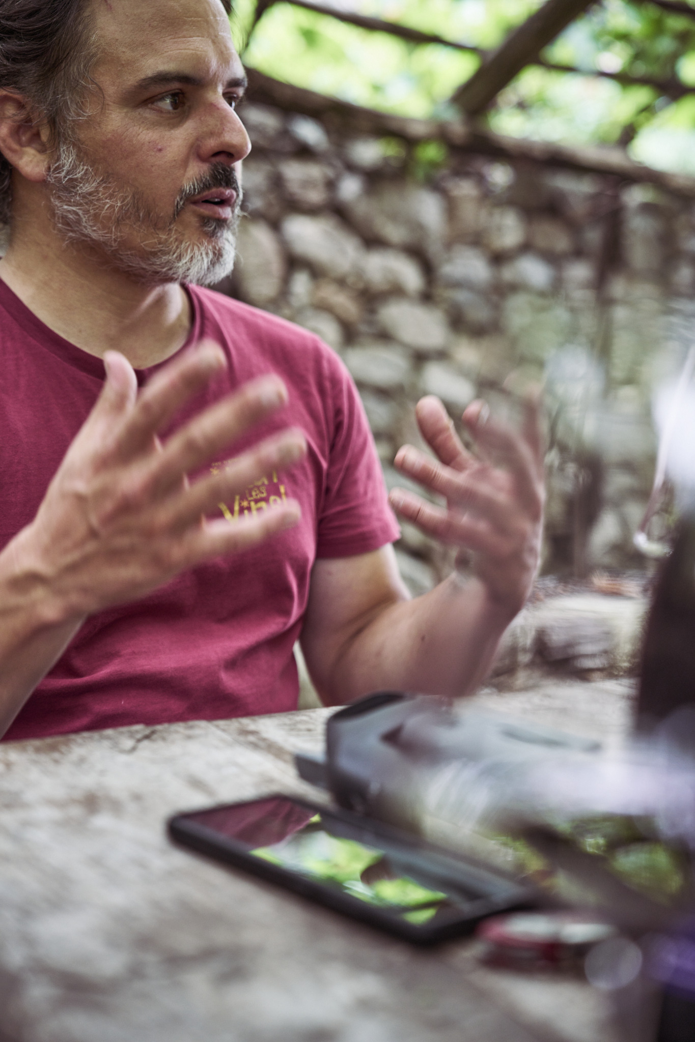 Dominic Würth conversa a un tavolo sotto una pergola
